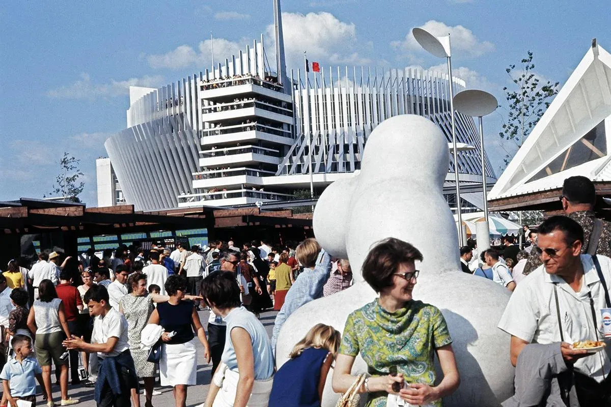 Väkijoukkoja Expo 67:ssä Montrealissa, valkoinen paviljonki ja suuri valkoinen veistos.