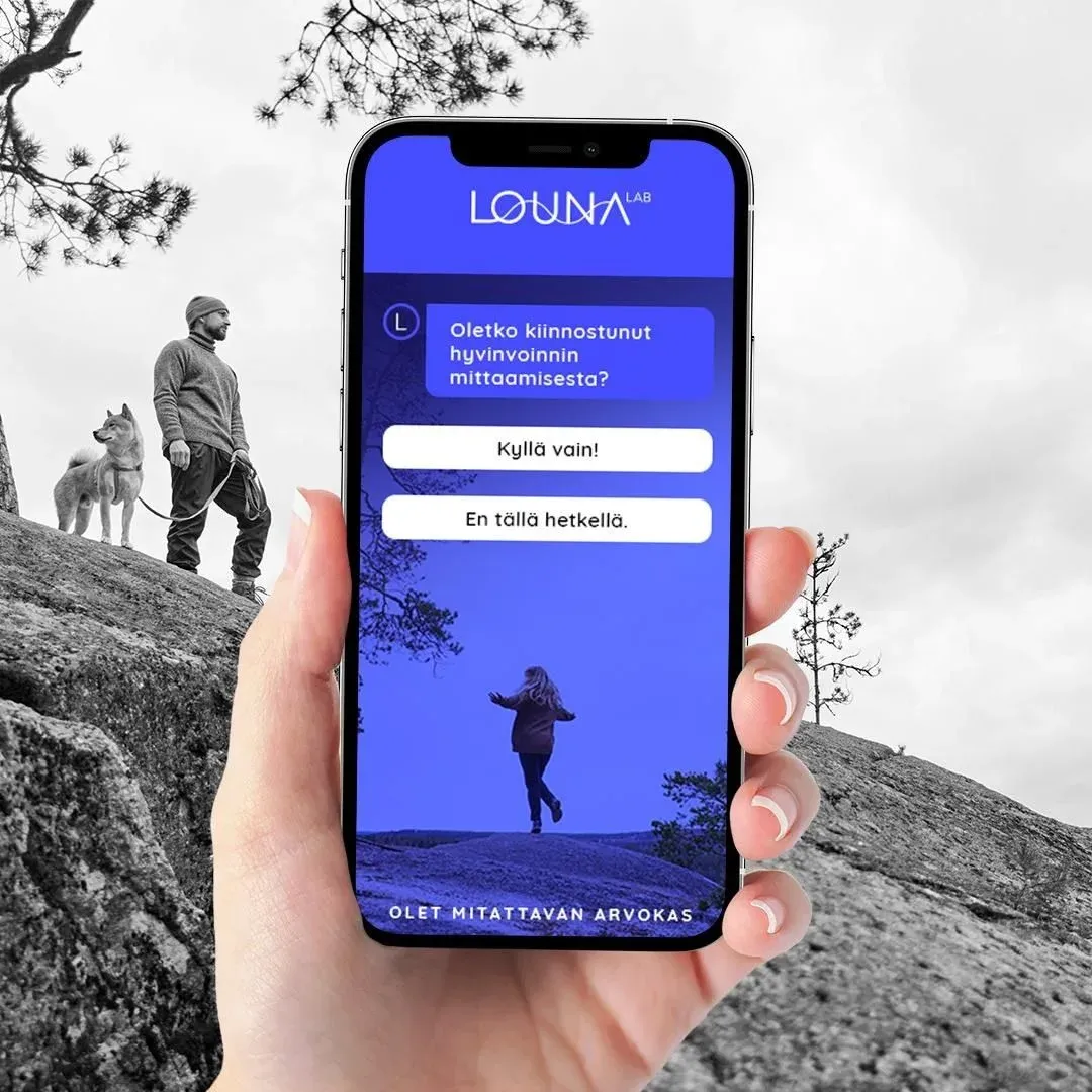 A hand holding a phone with a LounaLab chat that helps choose a test, in front of a black and white landscape.