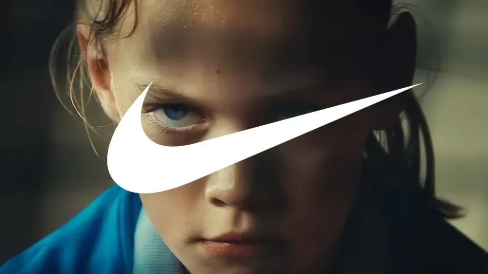 Nike swoosh over a close-up of a determined young athlete’s face.