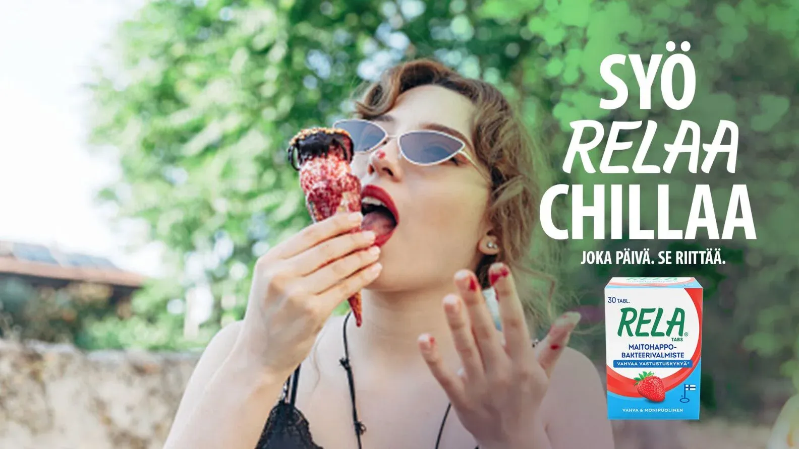 A woman in sunglasses licking an ice cream cone, beside the line Syö. RELAA. Chillaa. and a RELA pack.