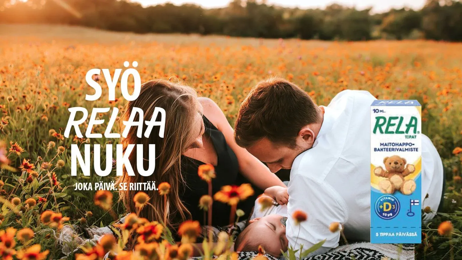 A couple lying in a field of flowers with a child, beside the line Syö. RELAA. Nuku. and a RELA pack.